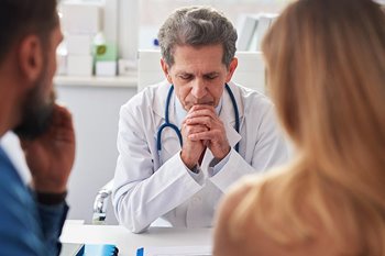 Concerned doctor talking to family