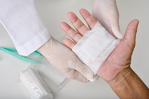 Doctor putting bandage on wound