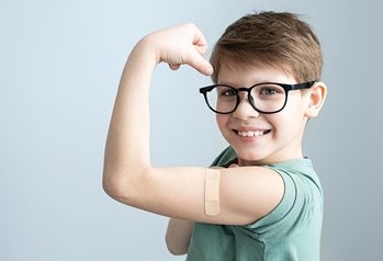 boy with bandaid flexing arm
