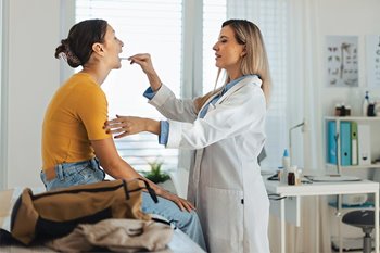 Doctor checking patient's throat