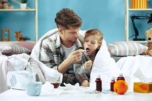 Father taking temperature of sick child