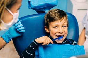 Child brushing teeth at dentist